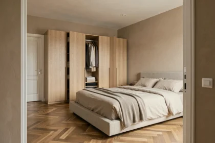 Armoire en chêne clair placée en face du lit dans une chambre moderne avec parquet en chevron